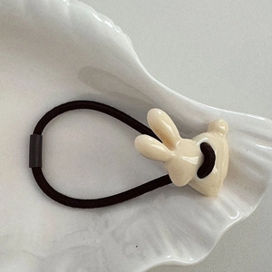 Detail eines süßen cremefarbenen Hasenanhängers an einem elastischen Haargummi