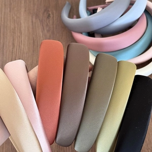 Detailed fan-out view showing multiple colors of padded satin headbands on wood