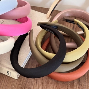 Detail of multi-colored sponge headbands with matte finish and handmade woven labels