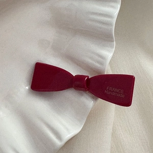 Détail de la barrette nœud bordeaux avec gravure FRANCE Handmade sur la résine polie