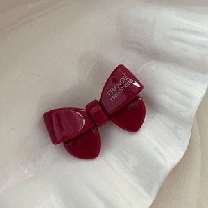 Détail d'une barrette nœud bordeaux en acétate avec inscription France Handmade dorée