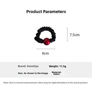 Detail view showing black scrunchie dimensions 7.5cm by 6cm with a red bead decoration