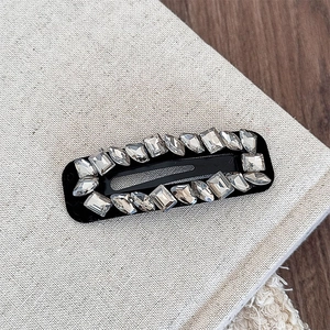 Detail view of premium black BB hair clip featuring sparkling multi-shape rhinestones