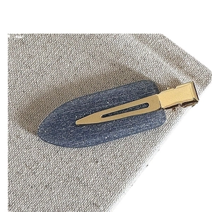 Barrette à cheveux mate bleu marine avec paillettes argentées sur fond de tissu rustique
