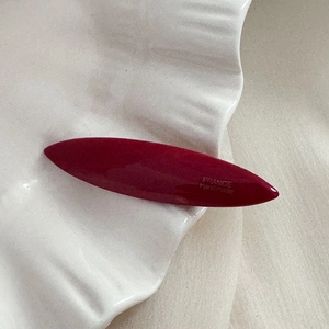 Gros plan d'une barrette à cheveux rouge vin faite main avec inscription France Handmade