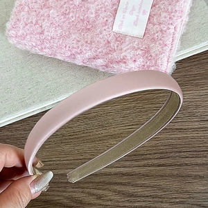 Détail d'un serre-tête large en satin rose avec texture de soie et doublure antiglisse