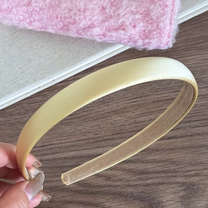 Détail d'un serre-tête en satin jaune avec éclat de soie et doublure velours antidérapante