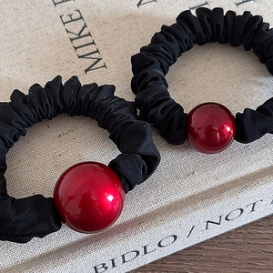 New Year red ball and black scrunchies elastic hair bands set on a textured book