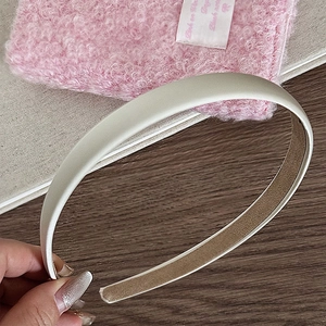 Vue détaillée du serre-tête en satin beige montrant la doublure antidérapante
