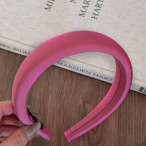 Detailed view of magenta padded satin headband with elegant silk texture and inner sewing