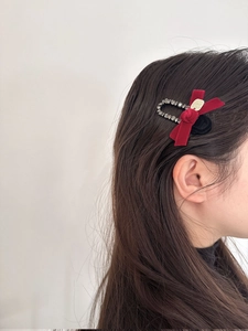 Close-up of velvet bow hair clip with sparkling rhinestones worn on hair
