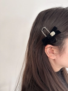 Detail of vintage velvet bow hair clip with rhinestones and gold relief plaque