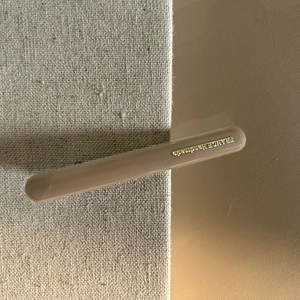 Dettaglio di un fermaglio per capelli marrone stile francese con scritta dorata