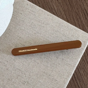 Close-up of caramel hair clip showing the golden France Handmade engraved detail