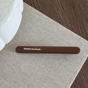 Close-up of a vintage brown resin hair clip featuring white France Handmade text detail