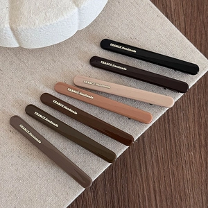 Set of seven vintage earth-toned resin hair clips with elegant gold France Handmade text