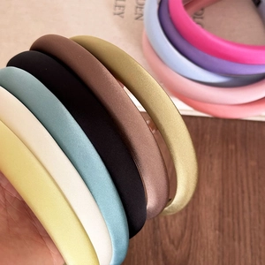 Macro shot of colorful padded silk headbands showing smooth satin texture and thick sponge