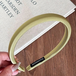 Detailed macro view of handmade silk texture wide headband in sage green metallic finish