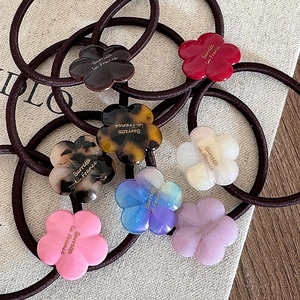 Lot de sept élastiques à cheveux fleurs en acétate coloré avec inscription dorée chic