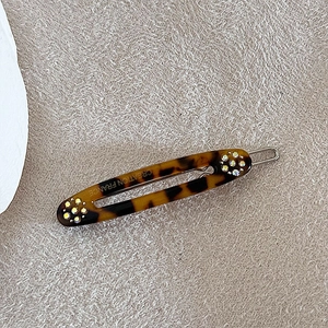 Detail van de schildpad-hars haarklem met kleine strass-steentjes en een metalen clip