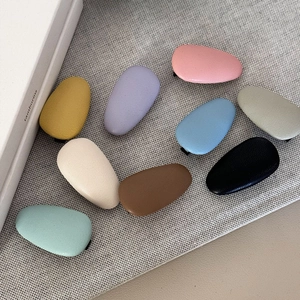 Minimalist leather drop hair clips in multi-color pastel tones on linen fabric background
