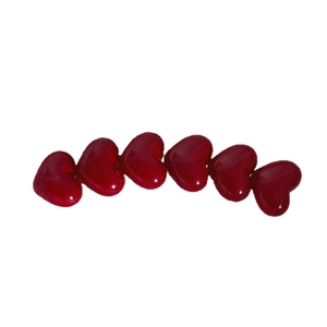 Set of six glossy red heart-shaped hair clips in curved arrangement on white background