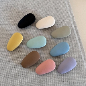 Minimalist matte leather teardrop hair clips set in 9 assorted cream colors on fabric