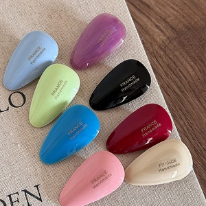 Detailed close-up of 8 colorful acetate teardrop hair clips on a linen fabric background