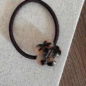 Détail de l'élastique cheveux fleur en écaille de tortue avec logo Barrette la France doré