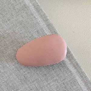 Detail view of oval matte hair clip in dusty pink on soft textured background
