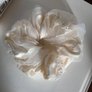 Detail of off-white organza scrunchie with layered silk texture and small white pearls