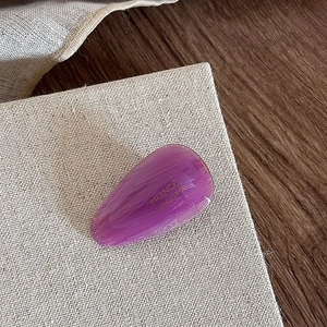 Close-up of a purple teardrop acetate hair clip with gold France Handmade lettering