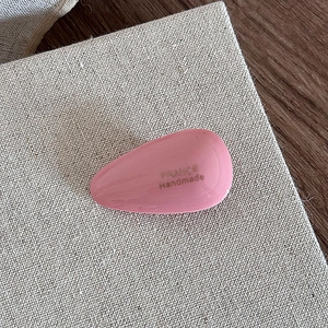 Close-up of pink acetic acid teardrop hair clip with golden France Handmade logo