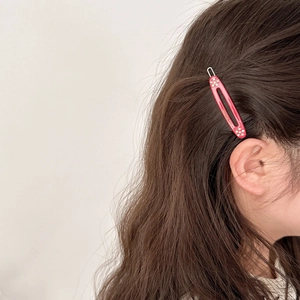 Elegante rode ovale haarclip met strassteentjes op bruin lang haar gedragen