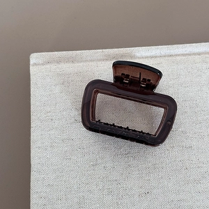 Detail shot of the translucent dark brown acrylic hair claw with minimalist square cutout