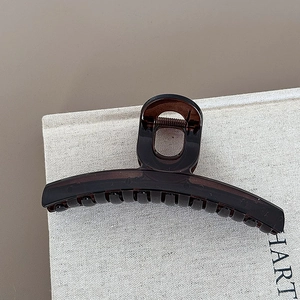 Detail view of the elegant translucent dark brown hair claw clip with a glossy finish