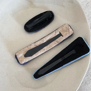 Close-up of three navy denim hair clips in oval, rectangular and teardrop shapes