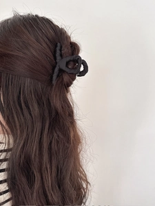 Minimalist black fabric wrapped shark hair claw clip on long wavy hair back view