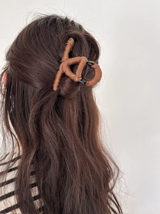Detailed back view of a brown fabric-wrapped claw clip on long wavy hair with wavy texture