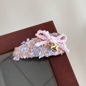 Detail einer Haarspange aus Tweed in Rosa und Lila mit Schleife und Herzanhänger