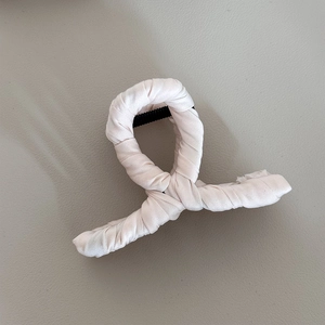 Detailed view of pink fabric wrap texture on the elegant shark hair clip accessory