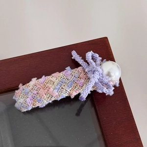Nahaufnahme der rosa-violetten Tweed-Haarspange mit Schleife und großer Kunstperle