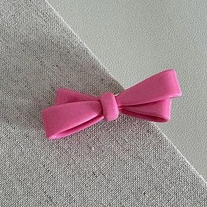 Detailansicht der rosa Harz-Schleife-Haarspange mit polierter Oberfläche und Glanz