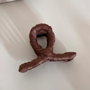 Detail of coffee brown satin wrapped hair claw clip with elegant fabric texture