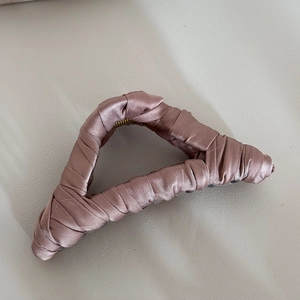 Detailed view of the handcrafted silk wrap texture on a large pink shark hair clip