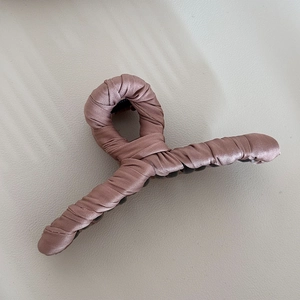 Detail of dusty pink satin fabric wrapped around a large hair claw clip accessory