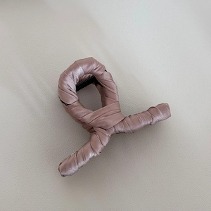 Detailed view of the elegant dusty pink satin fabric wrapped around a large hair claw clip