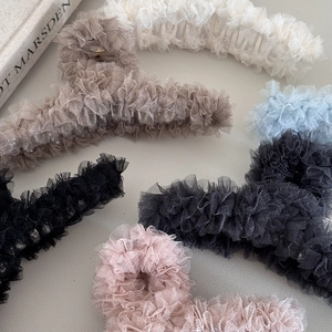Close-up of multi-color lace shark hair clips with textured mesh ruffles and soft pleats