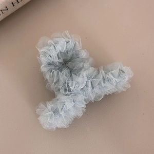 Détail de la pince à cheveux en tulle bleu clair avec texture de tissu plissé