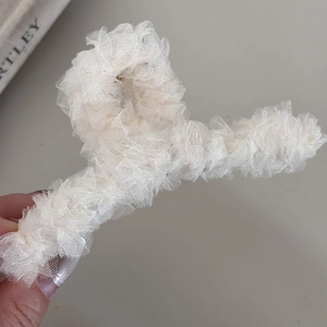 Close-up of cream lace shark hair clip showing detailed mesh pleats and durable claw